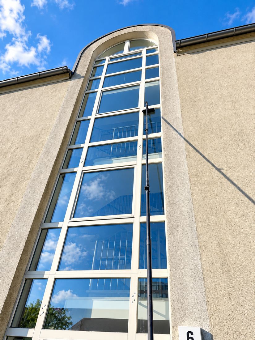 Hohes Treppenhausfenster an einer Fassade